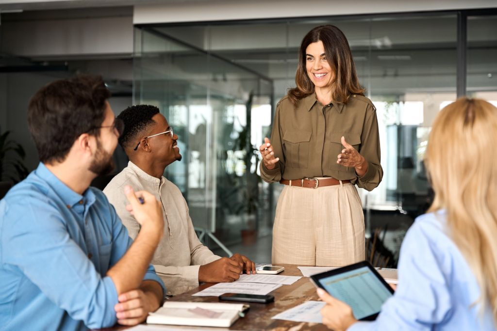 A group of employees around a table watching a presentation